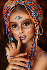 portrait of ethnic dancer colorful girl with big crown of beads. professional creative  makeup. face painting. third eye