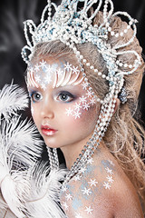 close up portrait of beautiful girl in ball dress with crown. professional winter makeup. little snow queen 