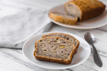 Fototapeta na wymiar Vegan banana bread loaf cake against white wooden background. Dessert food concept.