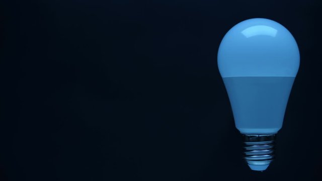 Energy-saving, eco-friendly Led bulb lamp lights up on a black background. There is a side space for your text. Closeup