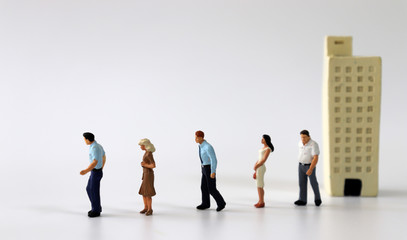 Fototapeta premium Miniature people walking out of miniature buildings. 