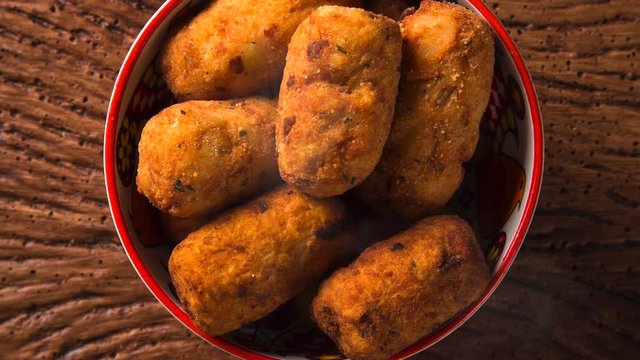 Cod fritters, traditional Spanish tapas Bunuelos de Bacalao with smoke. Top view.