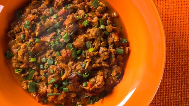 Sururu soup inside a orange plate. Brazilian dish with smoke. Top View.