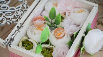 Wedding box with flowers and rings.
