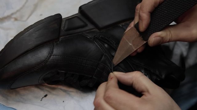 Shoemaker fixing shoe in his workshop