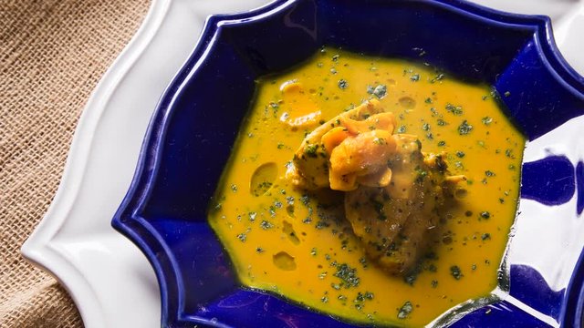 Pequi fruit with chicken over a wooden table with smoke. Frango com pequi.