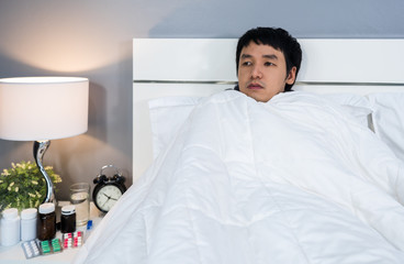 sick man feeling cold in blanket on bed at home