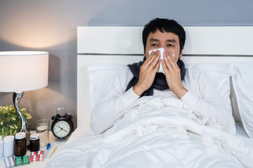 sick woman feeling cold and sneezing in bed