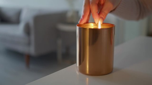 Woman Strikes a Match and Lights a Candle