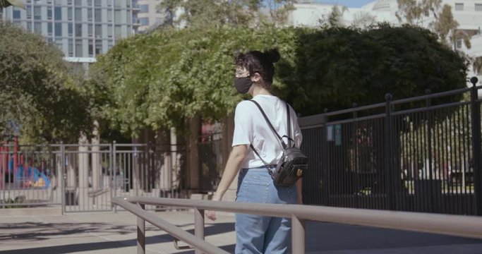 Woman in Face Mask Walks Along With Handrail in Down Town Los Angeles During Corona Virus Pandemic