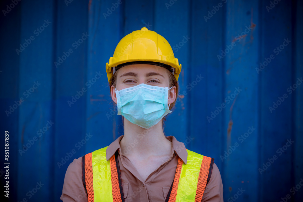 Wall mural portrait woman dock worker under working and checking production process on dock container warehouse