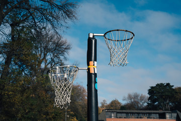 Netball goal ring and net against a blue sky and clouds at Hagley park, Christchurch, New zealand.