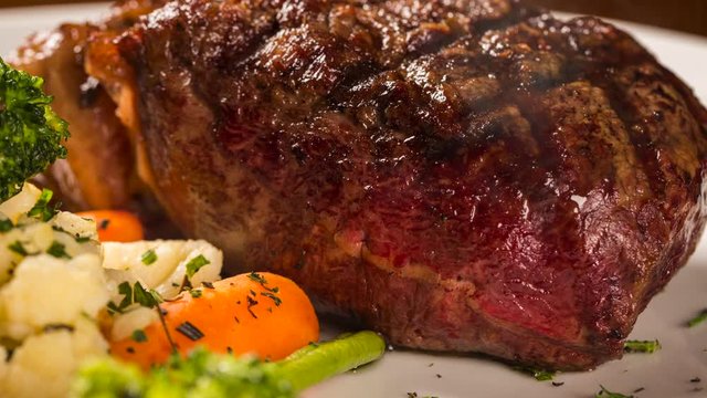 Grilled sirloin steak with grilled vegetables. Front view with smoke.