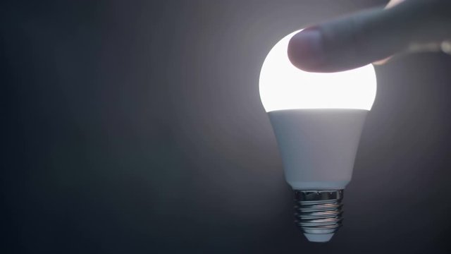 Energy-saving, eco-friendly Led bulb lamp lights up on a black background. You can see the structure of the led lamp. There is a side space for your text. Closeup