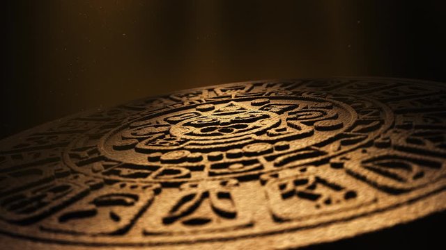 Mayan calendar rotates slowly under dramatic beams of light with floating dust particles. Ancient historic archaeology, stone carving from ancient civilisation