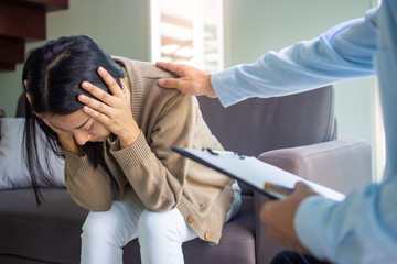 Psychologists  treat psychological symptoms, touch the shoulder of female patients with stress and depression. The doctor encourages and comforts the patient and treats the symptoms. 