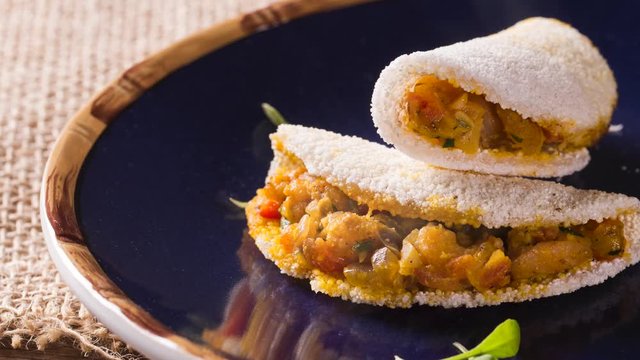 Delicious Tapioca, a brazilian snack made with cassava flour and shrimp, manioc on a blue plate. Front view with smoke.