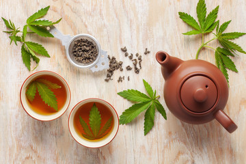 Cannabis herbal tea and marijuana leaves. Top view. Flat lay