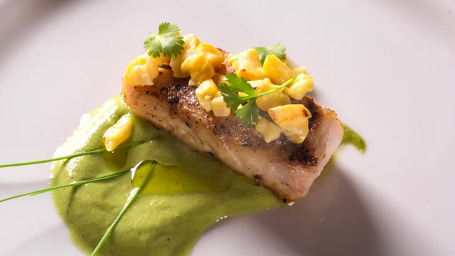 sea bass with green sauce and cashew fruit. Top view with smoke.