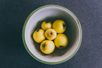plant-based ingredients, group of golden delicious apples in bowl on kitchen countertop