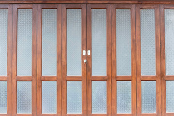 The door of the house is made of wood and decorated with glass with a pattern of flowers.