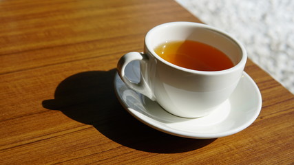 A cup of tea in the ceramics cup on the wooden table.