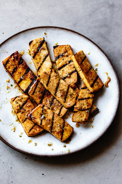 Grilled marinated tofu on a plate.