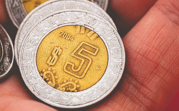 Mexican peso ( peso mexicano ). Currency of M&eacute;xico. Man holding in hand a mexican coins.
