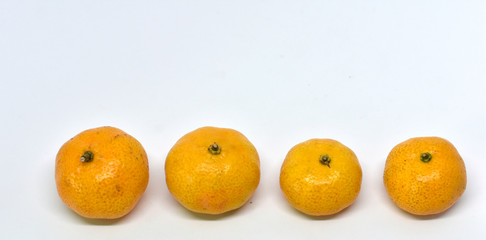 Many yellow tangerine ripe fruit is placed isolated on a white background.