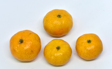 Many yellow tangerine ripe fruit is placed isolated on a white background.