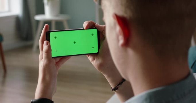 Man using a smart phone with mock up green screen, talking while having an online conference - online education, communications concept close up 4k video template