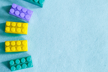 multi-colored parts of constructor. rectangular toys on a blue background. Concept of fine motor...