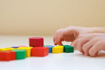 the child plays with colored figures. Details of the toy in the hands. Concept of development of fine motor skills, educational games, childhood, IVF, children's day, kindergarten. copy space