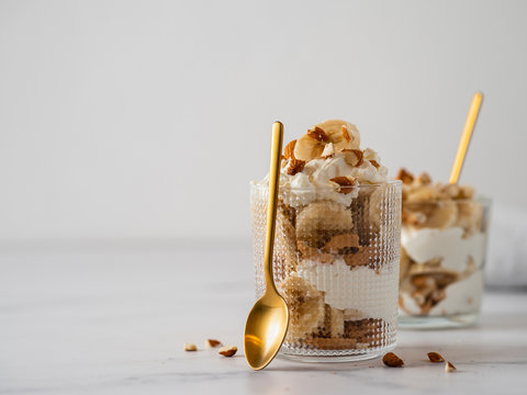 trifle dessert with banana, mascarpone, cookies and almonds