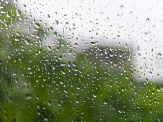 Rain on the glass,Dirty glass of raindrops, background landscape blurred