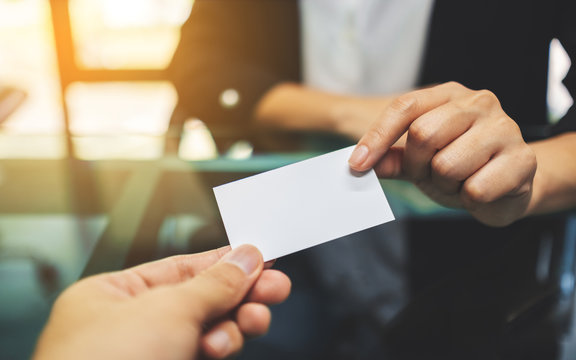 Two Businessman Holding And Exchanging A Blank Business Card