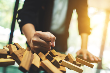 Businesswoman get angry and smashed down wooden blocks of Tumble tower game on table