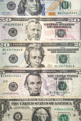 United States paper currency or cash layed fanned out on a table starting with a one dollar bill, five dollar bill, twenty, fifty and hundred making a great economic or business background.