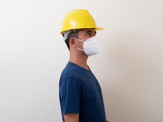 Asian industrial workers wear yellow hard hats, wear protective masks for their health