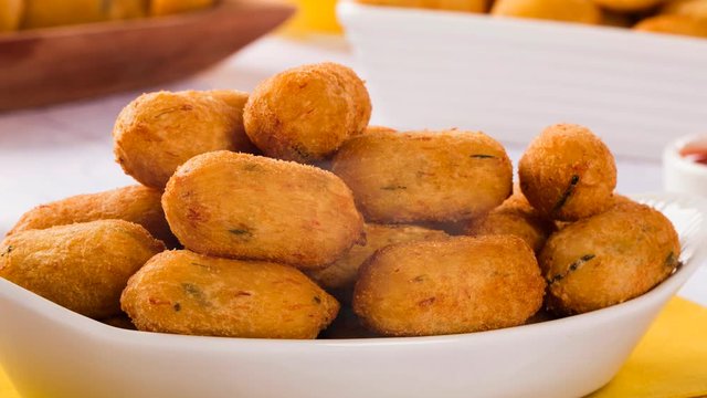 salt cod fritters, bunuelos de bacalao on the table with smoke.