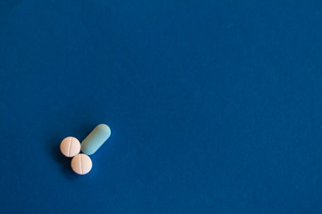 Representation of male genitalia with pills. Penis formed with pills on blue background.