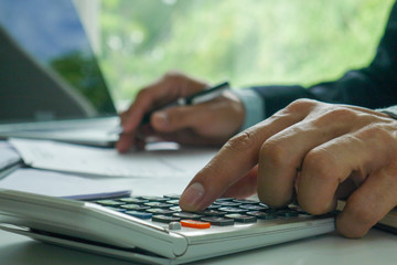 Businessmen hand press the calculator. Manager calculate the company's profits and losses. The concept of using a calculator with accounting and finance