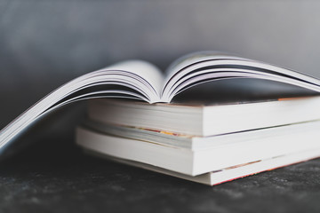 stack of books with one open on top of themshot from eye level with shallow depth of field