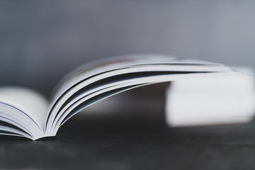 stack of books with one open on top of themshot from eye level with shallow depth of field
