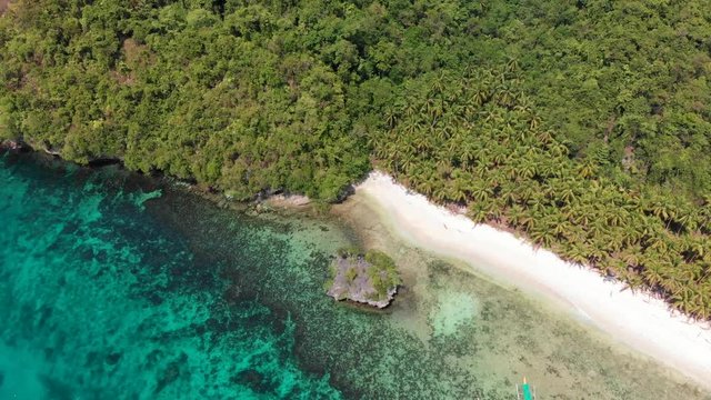 Aerial drone view of a secret white sand beach and blue transparent water in the Philippines. Wonders of the philippines, secret spot.