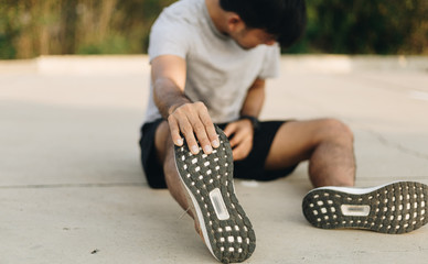 young man massaging  painful foot while exercising. Running sport injury concept.