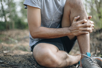 Young man massaging painful leg, concept of exercise injury