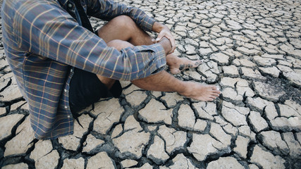 Farmers sitting on arid soil, Global warming