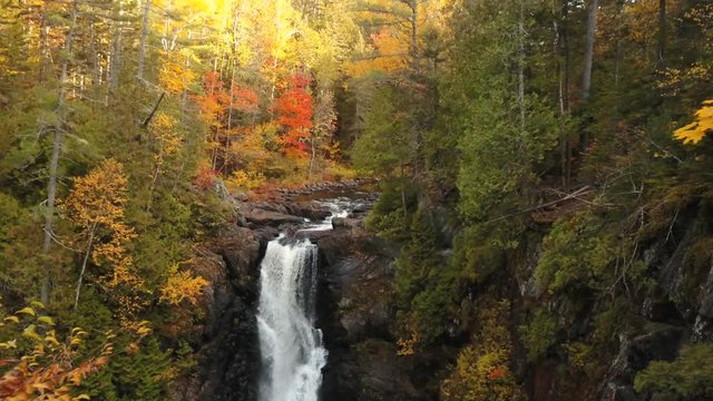 Aerial view of waterfall with fall foliage.