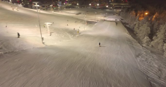 Arial view of some kids jumping some ski ramps in a snowpark in Lapland Finland